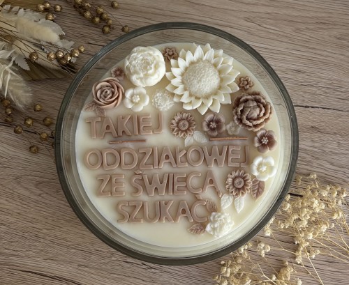 Świeca sojowa beżowo-kremowa z napisem.