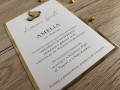 Zaproszenie wykonane na spodzie ze złotego papieru na wierzchu papier fakturowany z nadrukiem treści zaproszenia.