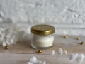 Świeca w słoiczku ze złotą nakrętką.