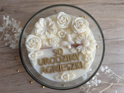 Świeca sojowa z kwiatami i personalizowanym napisem.