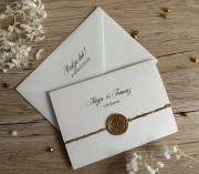 Eleganckie zaproszenie ślubne ze złoconym brzegiem i lakową pieczęcią oraz kopertą w komplecie.