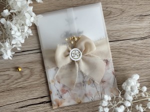 Zaproszenia na Pierwszą Komunię Świętą z beżową kokardą i symbolem IHS